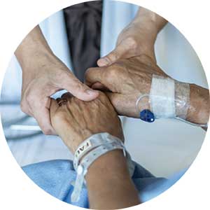 A patient holds hands with another person