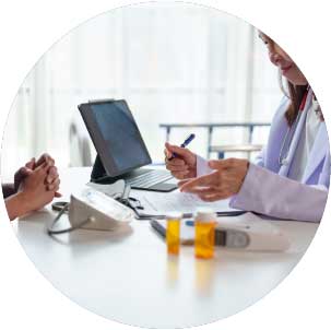 A doctor in a lab coat consults with a patient.