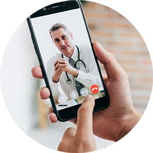 A person holds a phone while having a video call with a doctor