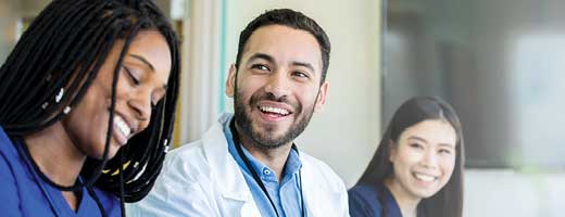 Three medical students laughing at a table